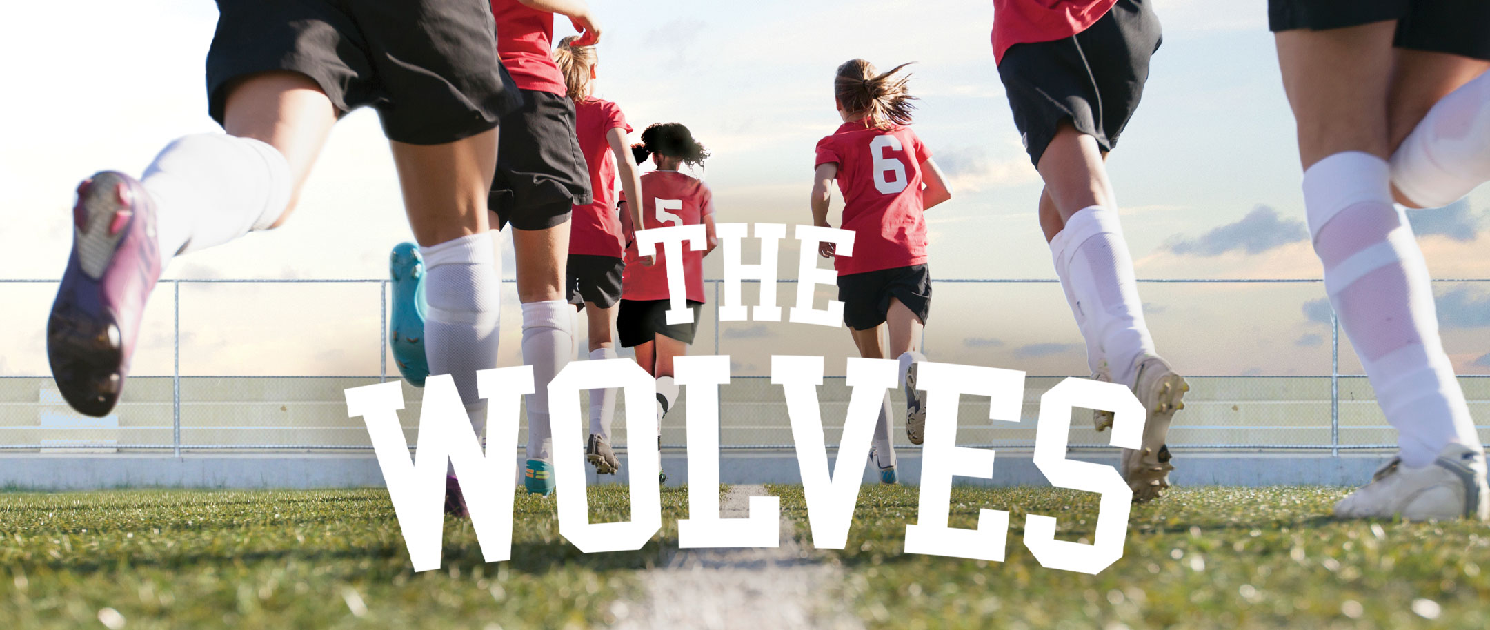 The Wolves | Womens soccer team in practice uniforms running toward the horizon on soccer field